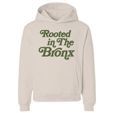 Cream hoodie with 'Rooted in The Bronx' text, NYC streetwear style