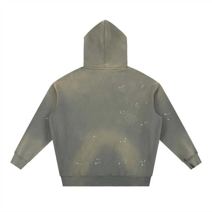 Olive green hoodie with white splatter paint design, bold streetwear style
