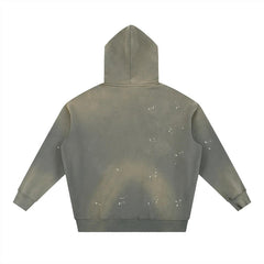Olive green hoodie with white splatter paint design, bold streetwear style