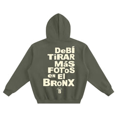 Olive green hoodie with 'Debí Tirar Más Fotos en El Bronx' text, NYC streetwear style