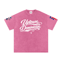Pink 'Uptown Dominican' streetwear tee with bold script, cartoon graphic, and color-block sleeve design